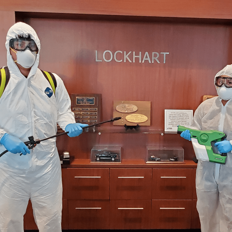 two people in protective suits standing in front of a display case